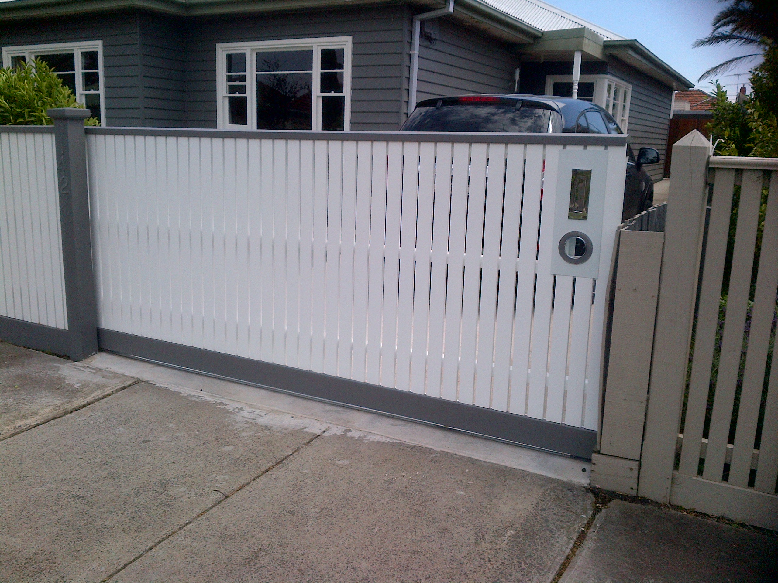 DIY sliding gate frame with white timber pickets